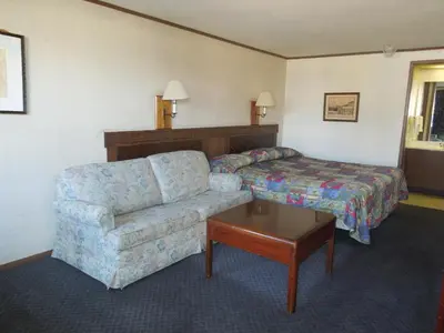 a hotel room with a couch and a bed at Xenia Country Inn in Xenia