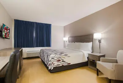 a hotel room with a bed and a chair at Red Roof Inn Lawrenceburg in Lawrenceburg