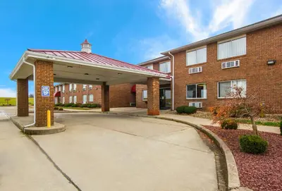 a large brick building with a parking lot at Red Roof Inn Lawrenceburg in Lawrenceburg
