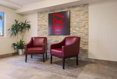 two red chairs in a waiting room with a red roof inn sign at Red Roof Inn Lawrenceburg in Lawrenceburg
