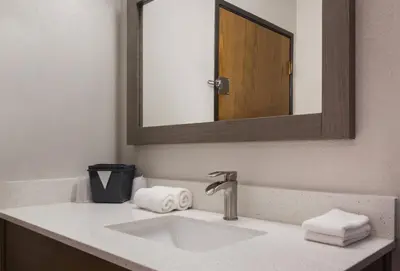 a bathroom with a sink with a mirror and towels at Red Roof Inn Lawrenceburg in Lawrenceburg