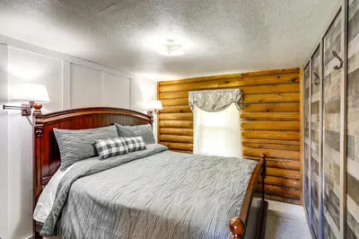 a bedroom with a bed and a wooden wall at Quiet Shiloh Retreat with Spacious Yard and Fireplace! in Shiloh