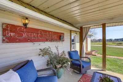 a porch with two chairs and a sign on the wall at Quiet Shiloh Retreat with Spacious Yard and Fireplace! in Shiloh