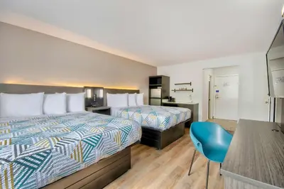 a hotel room with two beds and a blue chair at Studio 6 Georgetown KY Lexington North in Georgetown