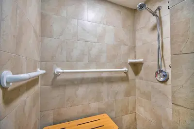 a bathroom with a shower with a bench in it at Studio 6 Georgetown KY Lexington North in Georgetown