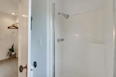 a shower in a bathroom with a glass door at Quaint Winesburg Cottage with Porch and Pond! in Dundee