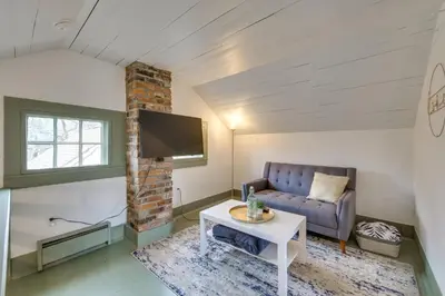 a living room with a couch and a tv at Quaint Winesburg Cottage with Porch and Pond! in Dundee