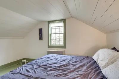 a bedroom with a bed in a room with a window at Quaint Winesburg Cottage with Porch and Pond! in Dundee