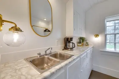 a kitchen with a sink and a mirror at Quaint Winesburg Cottage with Porch and Pond! in Dundee