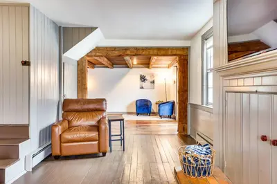 a living room with a chair and a table at Timeless Winesburg Farmhouse with Deck in Dundee