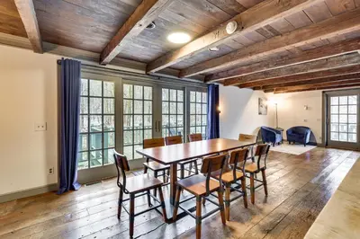 a dining room with a wooden table and chairs at Timeless Winesburg Farmhouse with Deck in Dundee