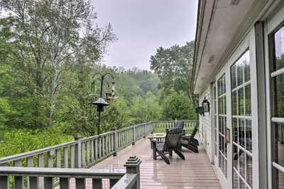a porch of a house with two chairs on it at Timeless Winesburg Farmhouse with Deck in Dundee