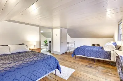 a bedroom with two beds and a mirror at Timeless Winesburg Farmhouse with Deck in Dundee