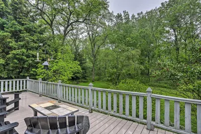 a wooden deck with a table and chairs on a fence at Timeless Winesburg Farmhouse with Deck in Dundee