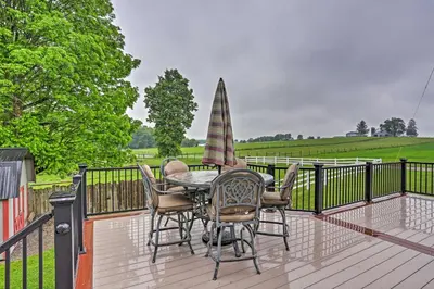 a patio with a table and chairs and an umbrella at Millersburg Home with Covered Porch and Fire Pit! in Millersburg