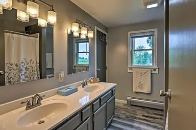 a bathroom with two sinks and a large mirror at Millersburg Home with Covered Porch and Fire Pit! in Millersburg