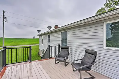 two chairs sitting on the deck of a house at Millersburg Home with Covered Porch and Fire Pit! in Millersburg