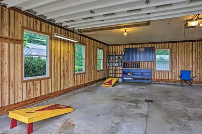 a room with wooden walls and a desk and a table at Millersburg Home with Covered Porch and Fire Pit! in Millersburg