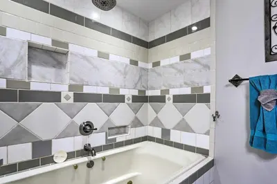 a bathroom with a white tub and a blue towel at Southeast Michigan Escape about 3 Mi to Adrian! in Adrian
