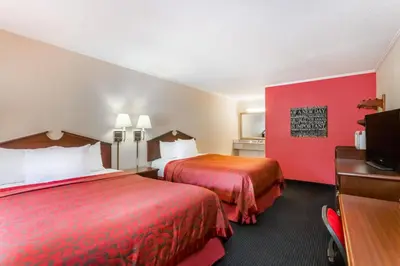 a hotel room with two beds and a flat screen tv at The Inn At Plantation in Weston