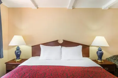 a hotel room with a bed with two lamps at The Inn At Plantation in Weston