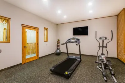 a gym with two exercise bikes and a flat screen tv at The Inn At Plantation in Weston