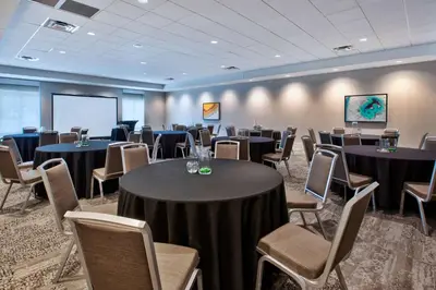 a conference room with tables and chairs and a screen at Hilton Garden Inn Columbus Easton, Oh in Columbus