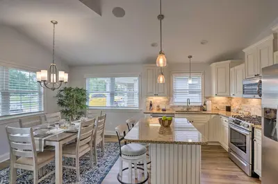 a kitchen with white cabinets and a table and chairs at Port Clinton Home with Lake Views! in Port Clinton
