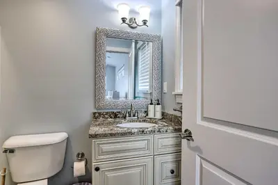 a bathroom with a toilet and a sink and a mirror at Port Clinton Home with Lake Views! in Port Clinton