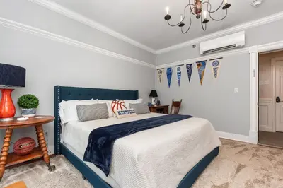 a bedroom with a blue and white bed and a table at The Benchmark Inn in Augusta