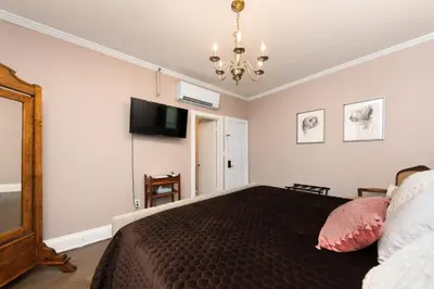 a bedroom with a bed and a tv on the wall at The Benchmark Inn in Augusta