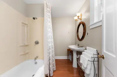 a bathroom with a tub and a sink at The Benchmark Inn in Augusta
