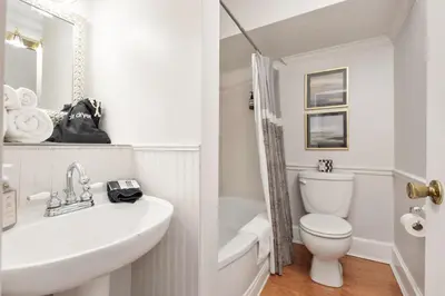 a white bathroom with a sink and a toilet at The Benchmark Inn in Augusta
