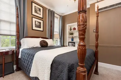 a bedroom with a bed with a wooden post at The Benchmark Inn in Augusta