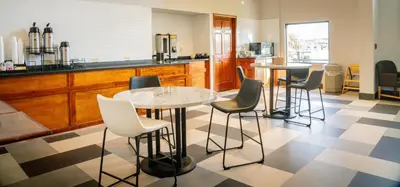 a kitchen with two tables and chairs and a counter at Royal Inn & Suites in Akron