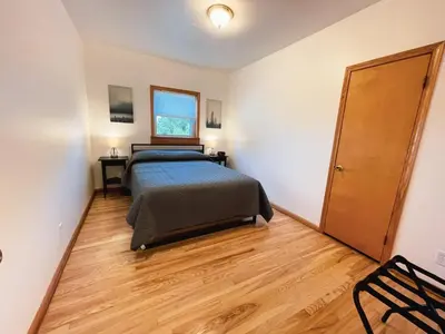 a bedroom with a bed and a wooden floor at 3 Bedroom home outside of Berlin, Patio with Hot Tub! in Millersburg