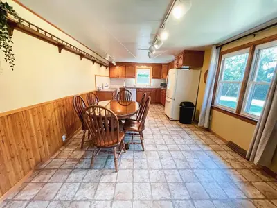 a kitchen with a table and chairs and a refrigerator at 3 Bedroom home outside of Berlin, Patio with Hot Tub! in Millersburg