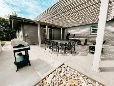 a patio with a table and chairs and a grill at 3 Bedroom home outside of Berlin, Patio with Hot Tub! in Millersburg