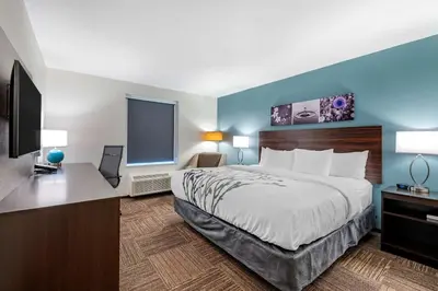 a hotel room with a bed and a flat screen tv at Sleep Inn in Georgetown