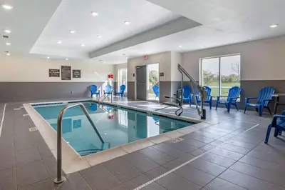 a swimming pool in a hotel room with blue chairs at Sleep Inn in Georgetown