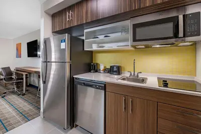 a kitchen with a stainless steel refrigerator and a sink at MainStay Suites Georgetown Lexington North in Georgetown