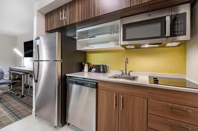 a kitchen with a stainless steel refrigerator and microwave at MainStay Suites Georgetown Lexington North in Georgetown