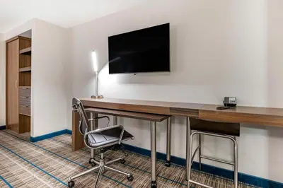 a room with a desk with a television and a chair at MainStay Suites Georgetown Lexington North in Georgetown