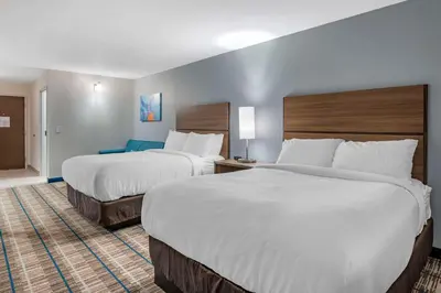 a hotel room with two beds with white sheets at MainStay Suites Georgetown Lexington North in Georgetown