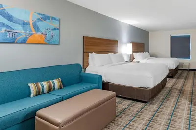 a hotel room with two beds and a couch at MainStay Suites Georgetown Lexington North in Georgetown