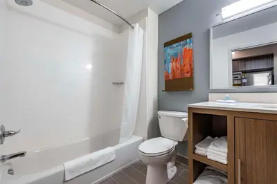 a bathroom with a tub and a toilet and a sink at MainStay Suites Georgetown Lexington North in Georgetown