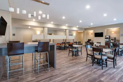 a restaurant with tables and chairs and a bar at MainStay Suites Georgetown Lexington North in Georgetown