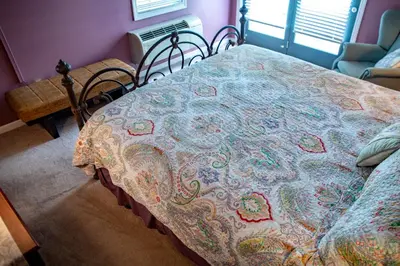 a bed with a blanket on it in a room at Elk River Hotel in Sutton