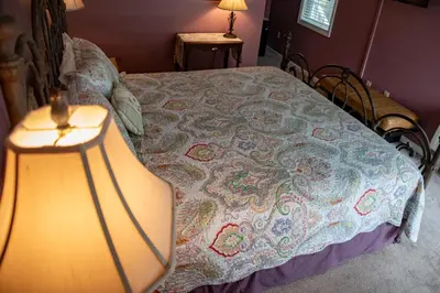 a bedroom with a bed with a lamp on it at Elk River Hotel in Sutton