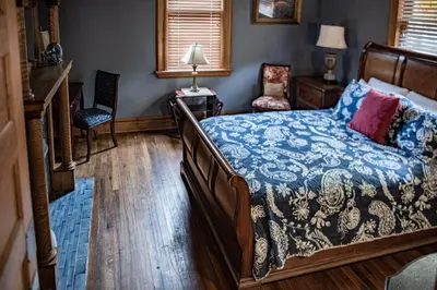 a bedroom with a bed with a blue and white comforter at Elk River Hotel in Sutton